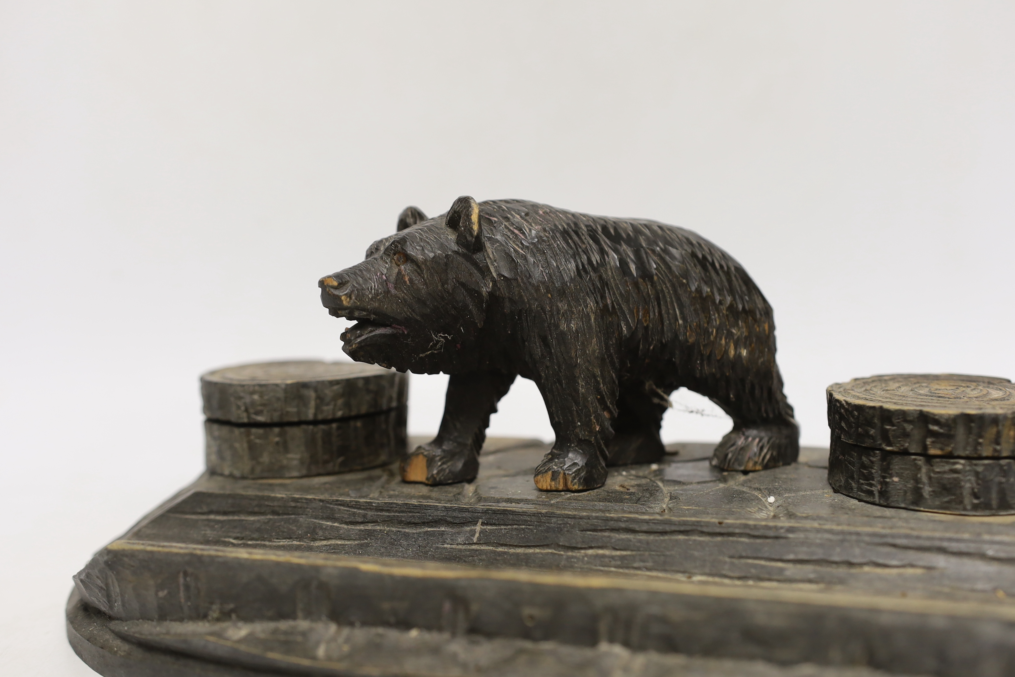 A Black Forest carved wooden inkstand, with ceramic inserts to the inkwells, 31cm wide